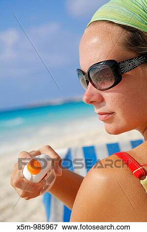Woman in sunglasses applying suntan lotion on a Caribbean beach View Large Photo Image Stock Photo - Woman in sunglasses applying suntan lotion on a Caribbean beach. Fotosearch