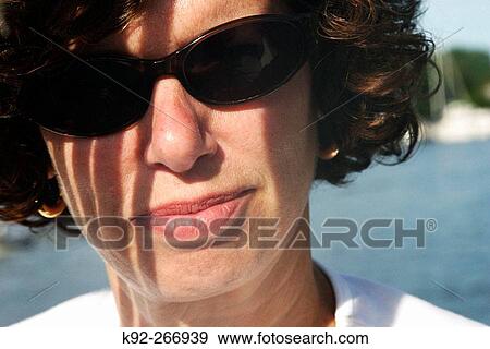 Woman in sunglasses in the sun View Large Photo Image Stock Photo - Woman in sunglasses in the sun. Fotosearch