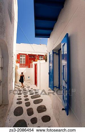Woman in the alleys of town center, Mykonos, Cyclades Islands, Greek Islands, Greece, Europe. View Large Photo Image Picture - Woman in the alleys of town center, Mykonos, Cyclades Islands, Greek Islands, Greece, Europe.. Fotosearch