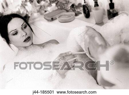 Woman in the bathtub shaving her leg View Large Photo Image Stock Image - Woman in the bathtub shaving her leg. Fotosearch