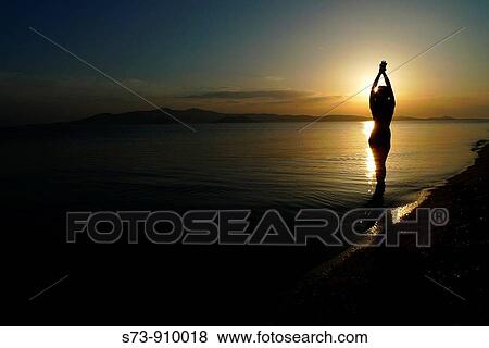 Stock Photo - Woman in the beach during the sunset, Naxos, Cyclades Islands, Greece, Europe. Fotosearch