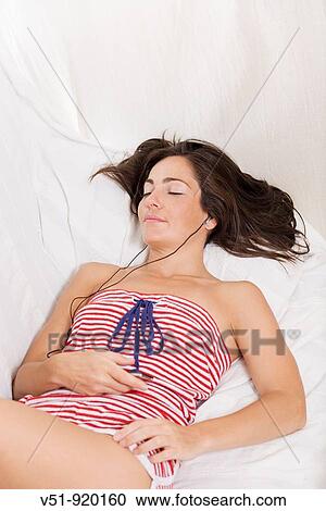 Woman in the couch listening to music View Large Photo Image Stock Image - Woman in the couch listening to music. Fotosearch