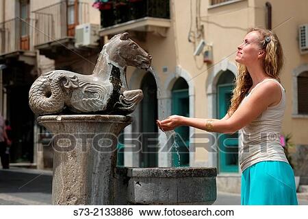 Woman in the Horse drinking fountain outside Cathedral of St Nicola, Taormina, Sicily, Italy View Large Photo Image Stock Photograph - Woman in the Horse drinking fountain outside Cathedral of St Nicola, Taormina, Sicily, Italy. Fotosearch
