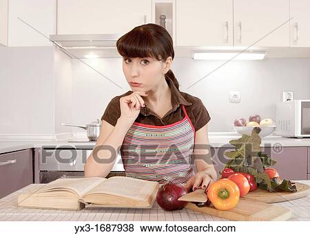 Woman in the kitchen is reading recipe book View Large Photo Image Stock Photo - Woman in the kitchen is reading recipe book. Fotosearch