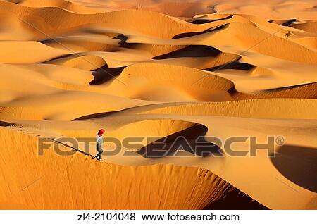 Stock Photo - Woman in the sand dunes of the empty quarter desert. United Arab Emirates, UAE, Abu Dhabi, Liwa Oasis, Moreeb Hill, Tal Mireb. Model Released.. Fotosearch