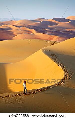 Woman in the sand dunes of the empty quarter desert. United Arab Emirates, UAE, Abu Dhabi, Liwa Oasis, Moreeb Hill, Tal Mireb. Model Released. View Large Photo Image Stock Photo - Woman in the sand dunes of the empty quarter desert. United Arab Emirates, UAE, Abu Dhabi, Liwa Oasis, Moreeb Hill, Tal Mireb. Model Released.. Fotosearch