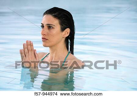 Picture - Woman in water, hands clasped. Fotosearch