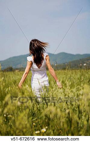 Woman in white dress walking in the countryside View Large Photo Image Stock Photograph - Woman in white dress walking in the countryside. Fotosearch