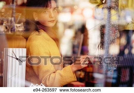 Woman inside a shop looking out the window View Large Photo Image Stock Photo - Woman inside a shop looking out the window. Fotosearch