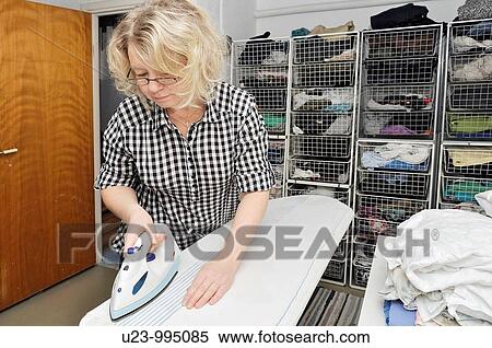 Woman ironing a cloth View Large Photo Image Stock Photography - Woman ironing a cloth. Fotosearch
