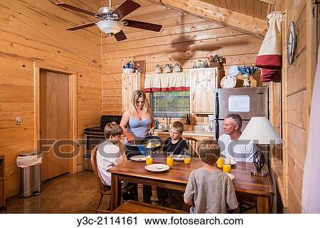 Woman is serving fried eggs as breakfast to her family of five. The male children and her husband are sitting at the kitchen table. View Large Photo Image Stock Image - Woman is serving fried eggs as breakfast to her family of five. The male children and her husband are sitting at the kitchen table.. Fotosearch