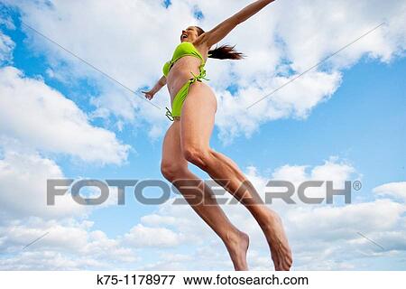 Woman jumping for joy at the beach View Large Photo Image Stock Photo - Woman jumping for joy at the beach. Fotosearch