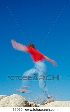 Woman jumping from one rock to another, Joshua Tree National Park, California, USA View Large Photo Image Stock Image - Woman jumping from one rock to another, Joshua Tree National Park, California, USA. Fotosearch