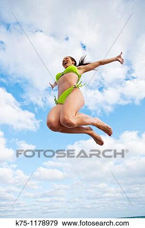 Woman jumping in the air at the beach View Large Photo Image Stock Photo - Woman jumping in the air at the beach. Fotosearch