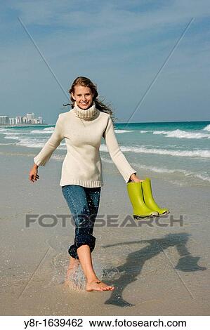 Stock Image - woman jumping next to seaside. Fotosearch