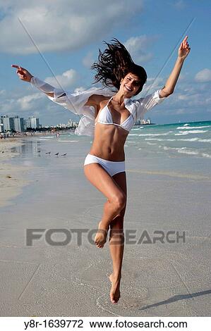 Stock Image - woman jumping seaside. Fotosearch
