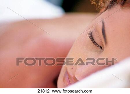 Stock Image - Woman laying down in an outdoor spa. Fotosearch