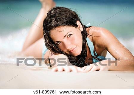 Woman laying in the sand by the sea View Large Photo Image Stock Image - Woman laying in the sand by the sea. Fotosearch