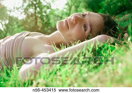 Woman laying on grass View Large Photo Image Stock Photography - Woman laying on grass. Fotosearch