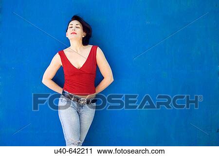 Stock Image - Woman leaning against wall. Fotosearch