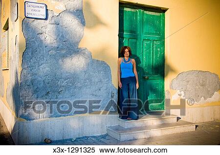 Woman leaning on a door in a corner of Pantelleria town, Pantelleria Island, Sicily, Italy View Large Photo Image Stock Photography - Woman leaning on a door in a corner of Pantelleria town, Pantelleria Island, Sicily, Italy. Fotosearch