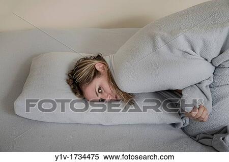 Stock Photography - Woman leaning on her bed. Fotosearch