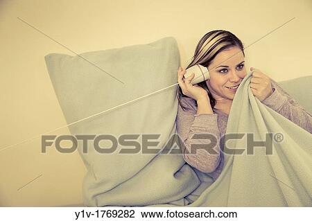Woman? listening? on a paper cup telephone View Large Photo Image Stock Image - Woman? listening? on a paper cup telephone. Fotosearch