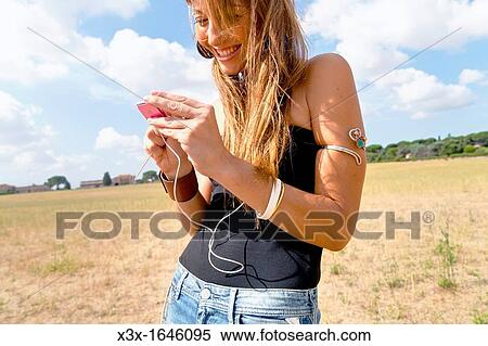 Stock Photography - Woman listening to ipod. Fotosearch