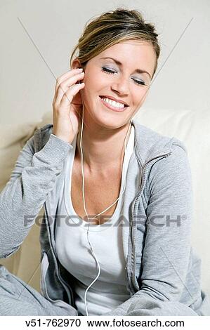 Woman listening to the MP3 in the couch View Large Photo Image Stock Image - Woman listening to the MP3 in the couch. Fotosearch