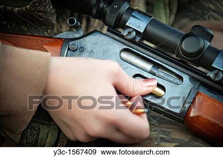 Woman loading hunting rifle gun with 30-30 ammunition cartridges View Large Photo Image Stock Photo - Woman loading hunting rifle gun with 30-30 ammunition cartridges. Fotosearch