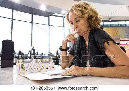 Woman looking at a menu in a restaurant, Seville, Spain View Large Photo Image Stock Photo - Woman looking at a menu in a restaurant, Seville, Spain. Fotosearch