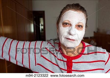 Stock Image - Woman looking at camera with moisturizing mask.. Fotosearch
