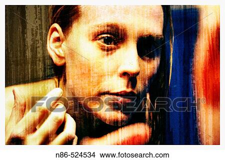 Picture - Woman looking at her own reflection in mirror. Fotosearch