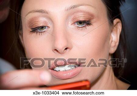 Woman looking at herself in the makeup mirror View Large Photo Image Picture - Woman looking at herself in the makeup mirror. Fotosearch