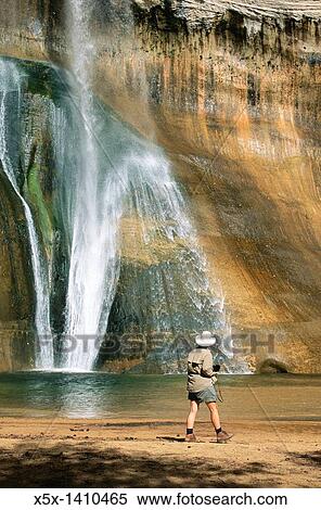 Woman looking at Lower Calf Creek Falls in the Escalante National Monument in Utah, USA View Large Photo Image Stock Photography - Woman looking at Lower Calf Creek Falls in the Escalante National Monument in Utah, USA. Fotosearch