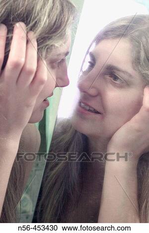 Stock Image - Woman looking at mirror. Fotosearch