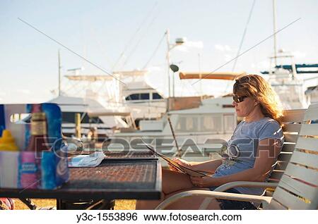 Woman looking at the menu of a seaside restaurant View Large Photo Image Stock Photograph - Woman looking at the menu of a seaside restaurant. Fotosearch