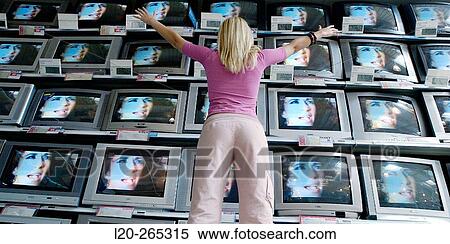 Woman looking at TVs in shopping center View Large Photo Image Stock Photography - Woman looking at TVs in shopping center. Fotosearch