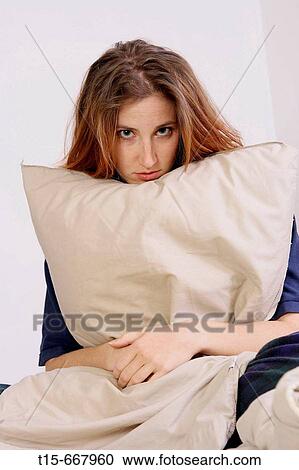 Woman looking depressed and sad feeling down holding a pillow sitting on bed View Large Photo Image Stock Image - Woman looking depressed and sad feeling down holding a pillow sitting on bed. Fotosearch