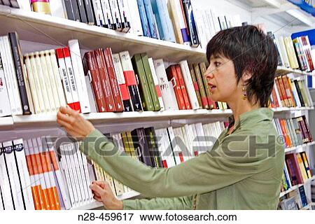 Stock Photo - Woman looking for books in a bookshop. Fotosearch