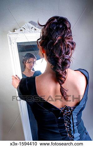 Woman looking in a mirror View Large Photo Image Stock Image - Woman looking in a mirror. Fotosearch