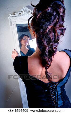 Stock Photo - Woman looking in a mirror. Fotosearch