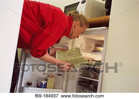Stock Photo - Woman looking in refrigerator. Fotosearch