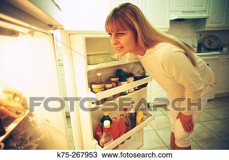 Woman looking into refrigerator View Large Photo Image Stock Image - Woman looking into refrigerator. Fotosearch