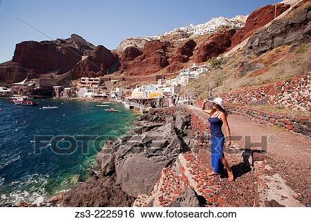 Woman looking out to the sea from the Ammoudi bay, Oia village, Santorini, Cyclades Islands, Greek Islands, Greece, Europe. View Large Photo Image Stock Photograph - Woman looking out to the sea from the Ammoudi bay, Oia village, Santorini, Cyclades Islands, Greek Islands, Greece, Europe.. Fotosearch