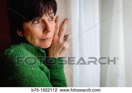 Woman looking through a window View Large Photo Image Stock Image - Woman looking through a window. Fotosearch