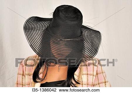 Stock Image - Woman looking through transparent brim. Fotosearch