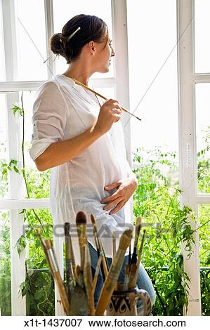 Stock Photo - Woman looking through window. Fotosearch