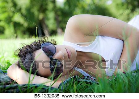 Woman lying down on grass View Large Photo Image Stock Photography - Woman lying down on grass. Fotosearch