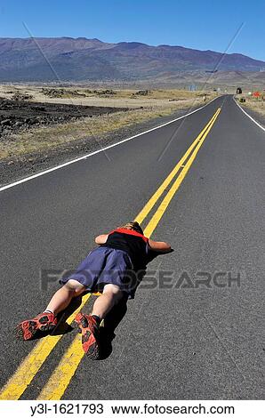 Woman lying down on the road dividing line, Mauna Kea Volcano, Big Island, Hawaii Islands, USA View Large Photo Image Stock Image - Woman lying down on the road dividing line, Mauna Kea Volcano, Big Island, Hawaii Islands, USA. Fotosearch